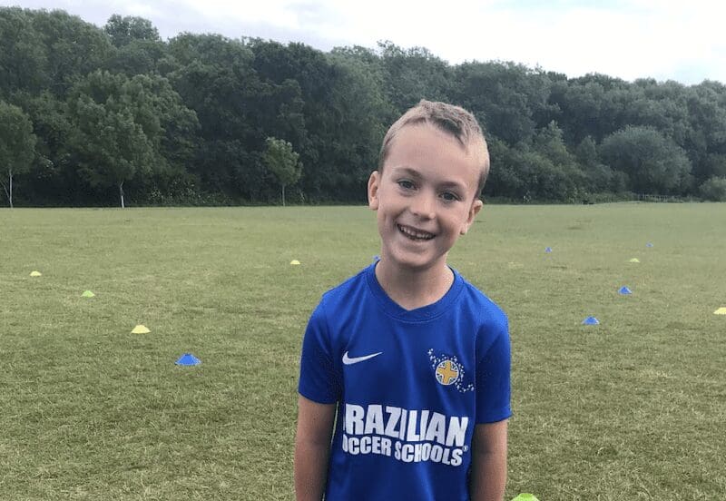 Football schools near me. Image shows a Brazilian Soccer Schools student outside on a football pitch in BSS kit.