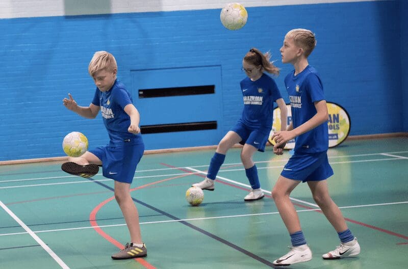 Kids football classes. Image shows a BSS football class with kids doing skills with footballs.